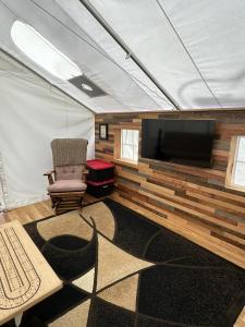a living room with a tv in a tent at GlampCamp in Big Arm