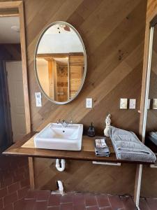 a bathroom with a sink and a mirror at GlampCamp in Big Arm +14 photos