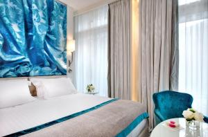 a bedroom with a bed and a blue painting on the wall at La Villa Haussmann in Paris