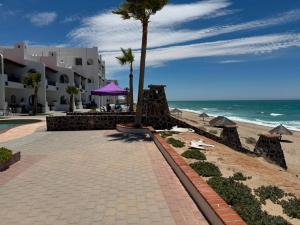 a walkway next to a beach with a palm tree at Paradise Villa #5 in Puerto Peñasco