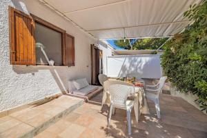 a patio with a table and chairs and a window at Le casette Punta Pizzo in Gallipoli