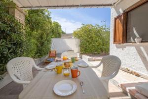 a wooden table with plates of food on a patio at Le casette Punta Pizzo in Gallipoli