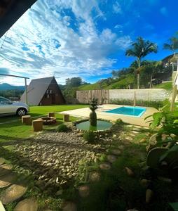 a backyard with a swimming pool and a house at Imperatriz Cabanas (Chalé 2 com piscina e hidro) in Santo Amaro da Imperatriz