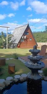 a fountain in front of a house with a barn at Imperatriz Cabanas (Chalé 2 com piscina e hidro) in Santo Amaro da Imperatriz