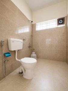 a bathroom with a white toilet and a window at Sai Grand Villas & Hotel Near Bengaluru Airport in Bangalore