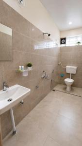 a bathroom with a sink and a shower and a toilet at Sai Grand Villas & Hotel Near Bengaluru Airport in Bangalore