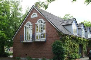 a small red brick house with a black roof at Hotel Borcharding Rheine Mesum in Rheine