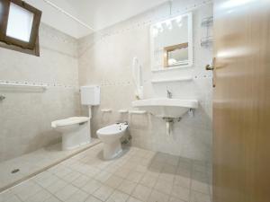 a white bathroom with a sink and a toilet at Le casette Punta Pizzo in Gallipoli