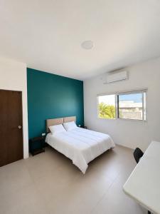 a bedroom with a large bed with a blue wall at Esterito Hostel in La Paz