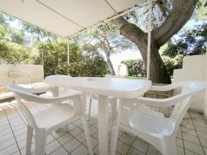 a white table and chairs on a patio with a tree at Le casette Punta Pizzo in Gallipoli +90 photos