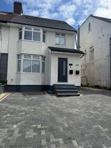 a white house with a blue door and a driveway at Luxury Budget Flat in Middlesex in Colindale