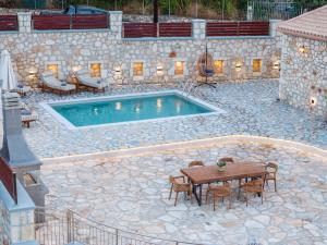 a swimming pool with a table and chairs and a table and a table at Villa Amantia in Chaliotata