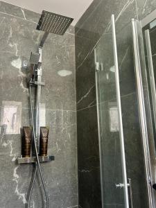 a bathroom with a shower with a shower head at Luxury Budget Flat in Middlesex in Colindale +45 photos