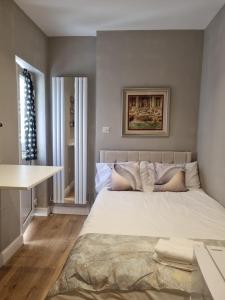 a bedroom with a large bed and a table at Luxury Budget Flat in Middlesex in Colindale
