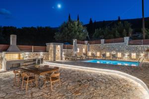 a patio with a table and chairs next to a pool at Villa Amantia in Chaliotata