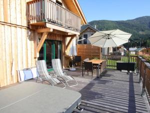 a wooden deck with a table and an umbrella at Wolkenheim in Hohentauern