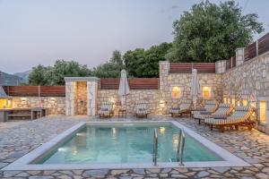 a pool in a patio with chairs and a table at Villa Amantia in Chaliotata