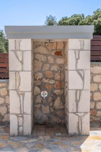 a building with a stone wall with a hose at Villa Amantia in Chaliotata +37 photos