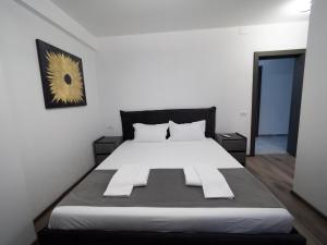 a bedroom with a large white bed in a room at NORTH GATE Rooms in Afumaţi