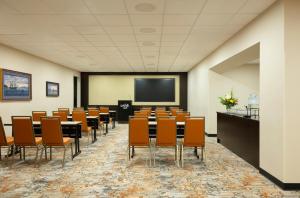 a conference room with tables and chairs and a screen at The Hotel Captain Cook in Anchorage +31 photos