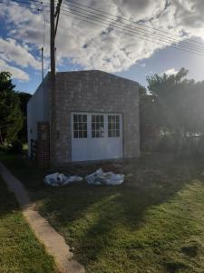 a small brick house with a white garage at Cabaña-Villa General Savio in Sánchez