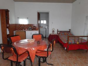 a room with a table and chairs and a bed at Cabaña-Villa General Savio in Sánchez