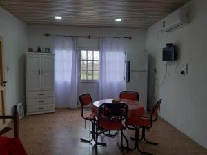 a dining room with a table and chairs and a window at Cabaña-Villa General Savio in Sánchez