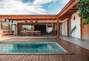 an outdoor patio with a swimming pool and a wooden deck at Casa Orybá in Prado