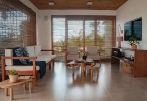 a living room with a couch and tables andwindows at Casa Orybá in Prado