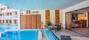 a large swimming pool in a building with a room at U North Coast in Sidi Kirayr