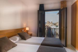 a bedroom with a bed and a window with a view at Hotel Alta Garrotxa in Tortellá
