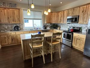 a kitchen with wooden cabinets and a kitchen island with chairs at Hometown Place in Missoula