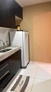 a kitchen with a white refrigerator and a sink at Aprt com ar varada conjugada,piscina in Aracaju