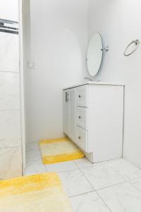 a white bathroom with a mirror and a dresser at The Grand View Beachfront Villa - Sleeps up 10 in Nassau