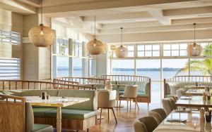 a restaurant with tables and chairs and a view of the ocean at The Beachcomber Hotel & Resort in Toukley