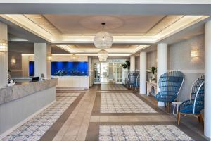 a lobby of a hotel with blue chairs at The Beachcomber Hotel & Resort in Toukley