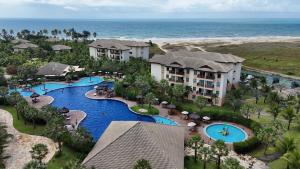 an aerial view of a resort with a pool and the ocean at Vg Sun Cumbuco 112 in Caucaia