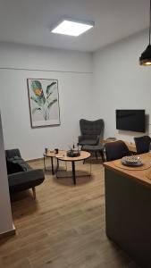 a living room with couches and a table and a tv at Luxury Green Apartment in Serres