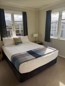 a large bed in a bedroom with windows at Bristol Motel - HOUSE in Upper Hutt