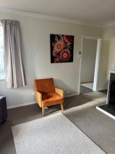 a living room with a chair and a painting on the wall at Bristol Motel - HOUSE in Upper Hutt