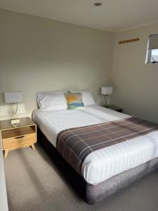 a bedroom with a large bed and a night stand at Bristol Motel - HOUSE in Upper Hutt