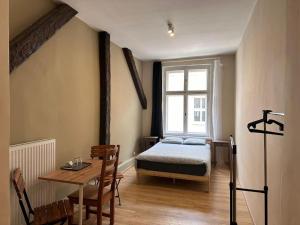 a bedroom with a bed and a table and a window at Apolla 12 in Poznań