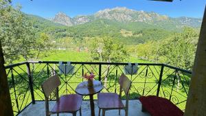a table and chairs on a balcony with mountains at Kulla e Vjetër ,Vermosh in Vermosh