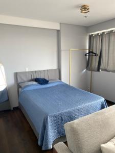 a bedroom with a bed with a blue blanket at The Cittyplex Osasco - new flat in Osasco +8 photos