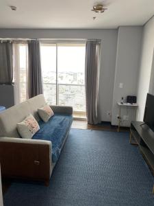 a living room with a couch and a large window at The Cittyplex Osasco - new flat in Osasco