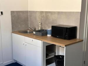 a kitchen counter with a microwave and a sink at StayPoz-Stary Rynek in Poznań