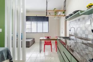 a kitchen with a table and red chairs in it at Studio the city center 300m Pelourinho HAI0203 in Salvador