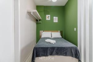 a green bedroom with a bed with a towel on it at Studio the city center 300m Pelourinho HAI0203 in Salvador