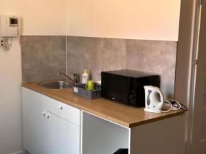 a kitchen counter with a microwave and a sink at StayPoz-Stary Rynek in Poznań