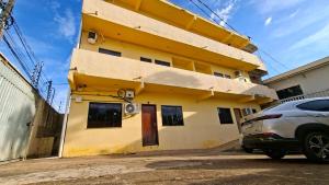 a yellow building with a car parked in front of it at Studio Executivo Completo com Garagem , Ar e Wi-fi in Parauapebas